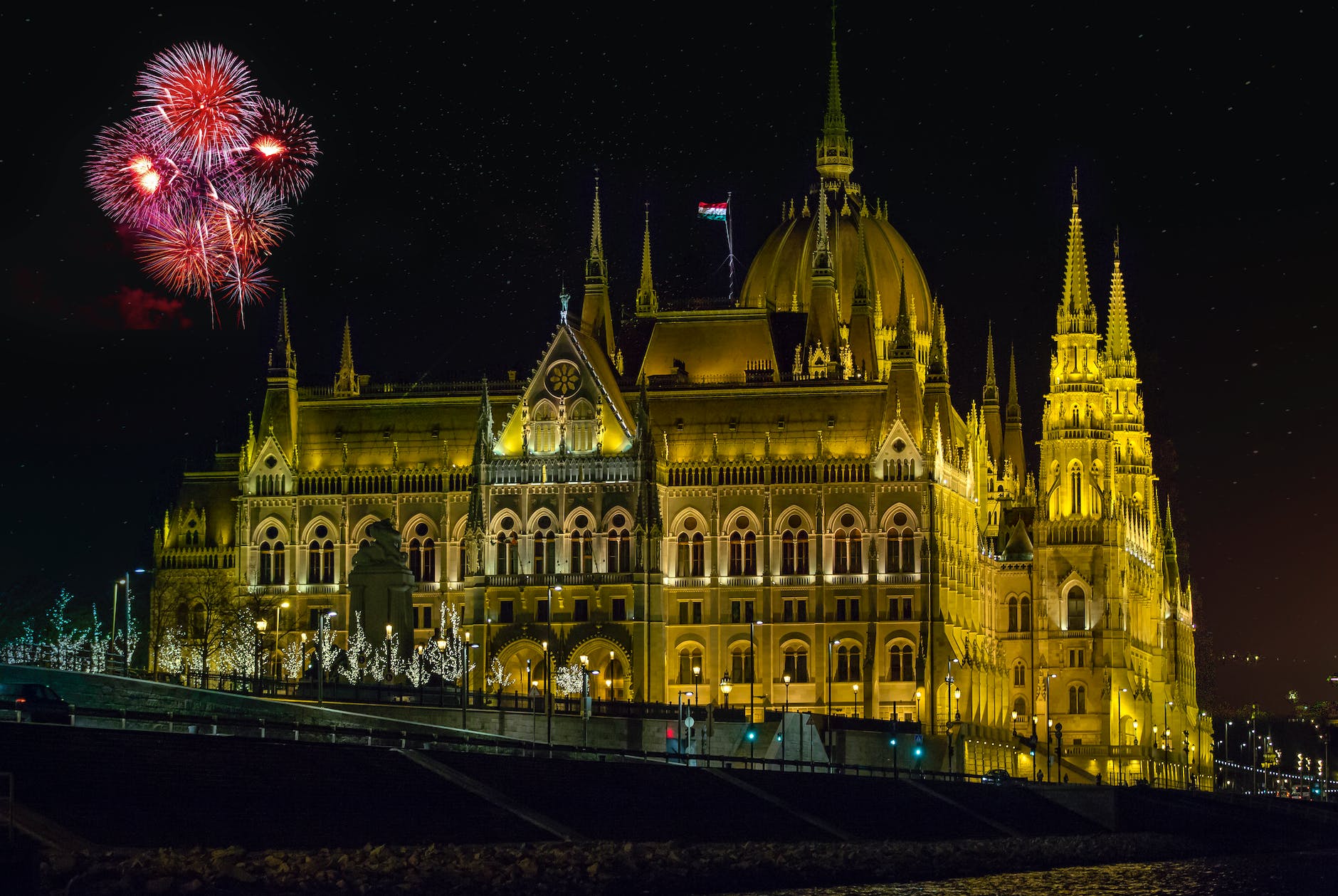 hungarian parliament building with fireworks in night sky